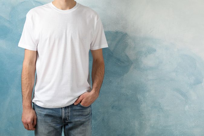 Men in blank t-shirt against blue background, space for text