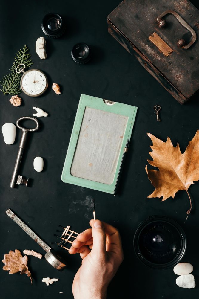 Hand lighting match with of vintage items on desk