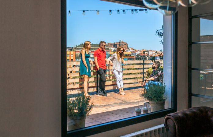 View of friends group talking in rooftop through lounge window