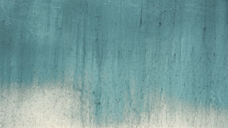 Textured turquoise concrete wall with weathered gradient and rough surface