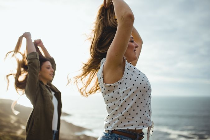 Happy female travelers enjoying freedom at seaside