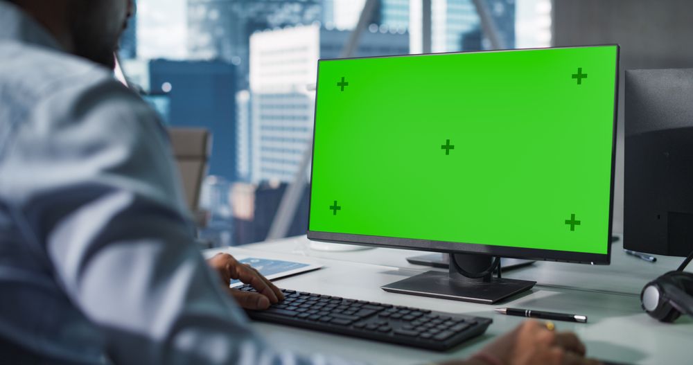 Indian Chief Financial Officer Working on Desktop Computer with Green Screen Mock-Up Display.