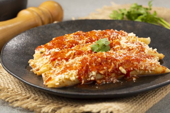 Pancakes stuffed with minced meat and topped with tomato sauce and grated cheese.