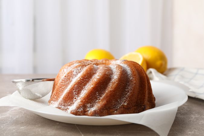 Cake with powder sugar on grey table, close up