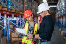 Male and female checking inventory distribution before shipping