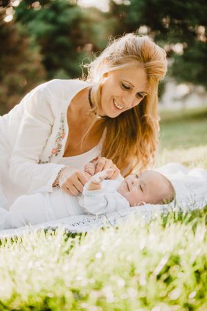baby with down syndrome lying on a blanket with her grandmother