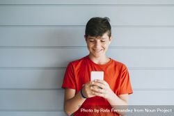 Profile of a happy male teen texting on a smart phone with copy space 49mRdy