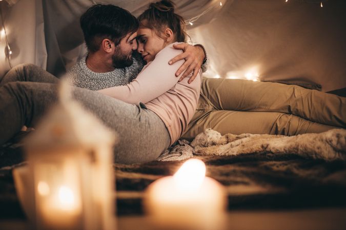 Couple on bed at home in candle light