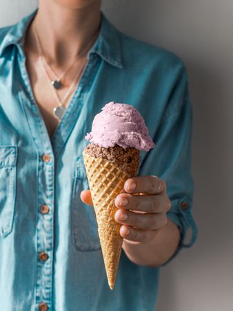 Ice cream scoop in cone in woman hands