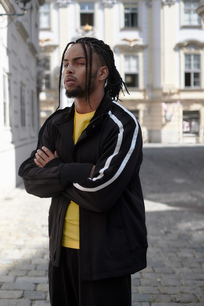 Black male standing with arms crossed