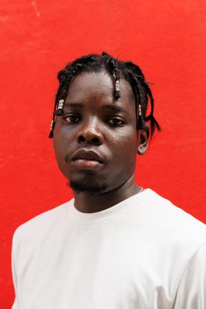 Black man with unique hair, Standing at red background