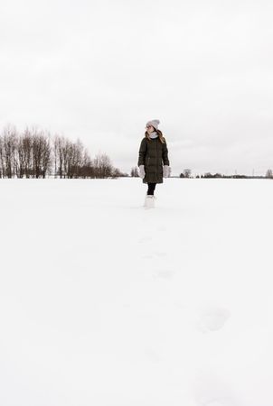 Woman jumping between snow field