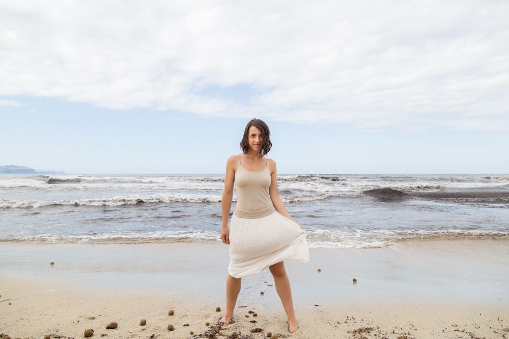 Charming young woman on shore near water