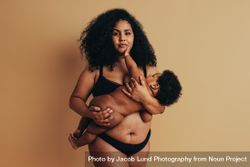 Postpartum mother breastfeeding her baby bxYjy0