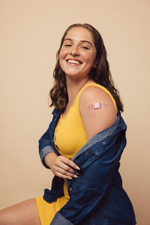 Beautiful woman showing her arm after receiving a vaccine