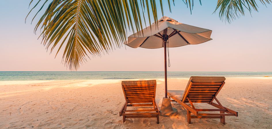 Two lounge chairs reclining at the beach