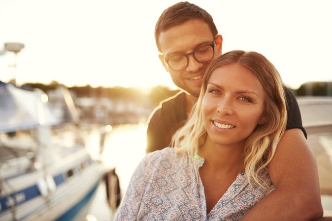 Couple on yacht with man’s arm over the woman’s shoulder