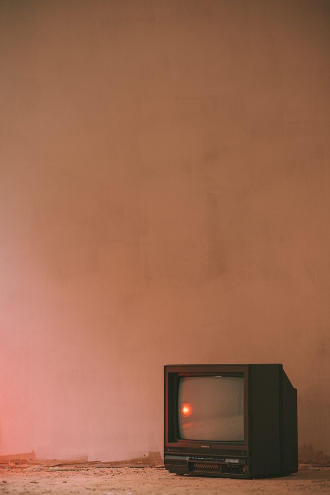 CRT tv against pink wall