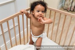 Cute baby boy in diaper in crib 4Z3lWb