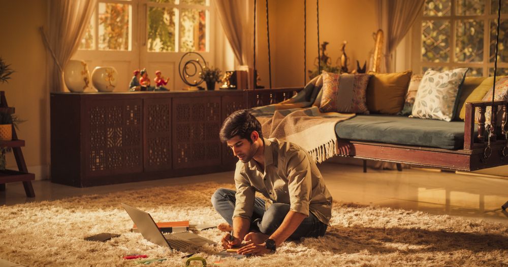 Focused Indian Man Studying at Home: Engaged in Learning, Researching, and Project Management.