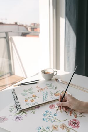 Person drawing flowers with watercolor