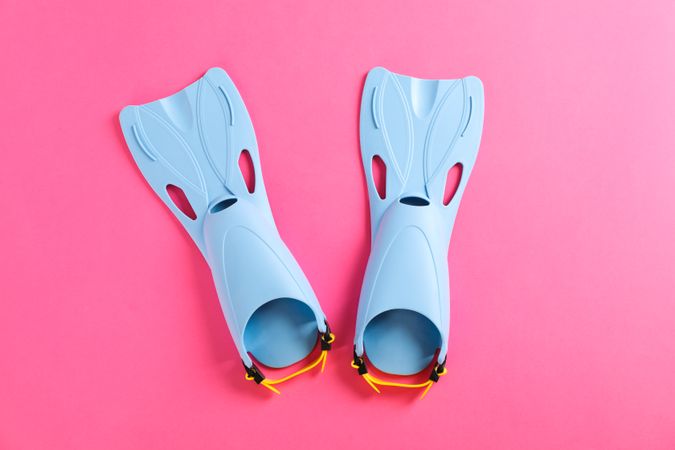 Blue flippers on pink background, space for text