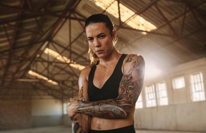 Fitness woman inside abandoned warehouse after training session