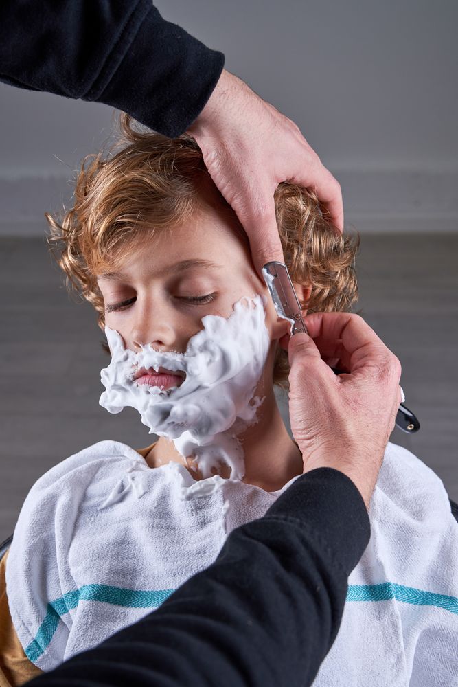 Boy shaving in a barbershop