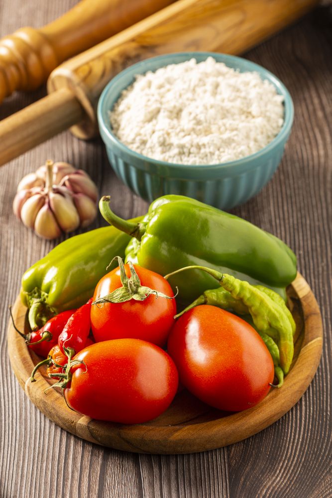 Wooden table with ingredients for pizza.
