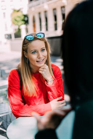 Young woman looking at friend in cafe