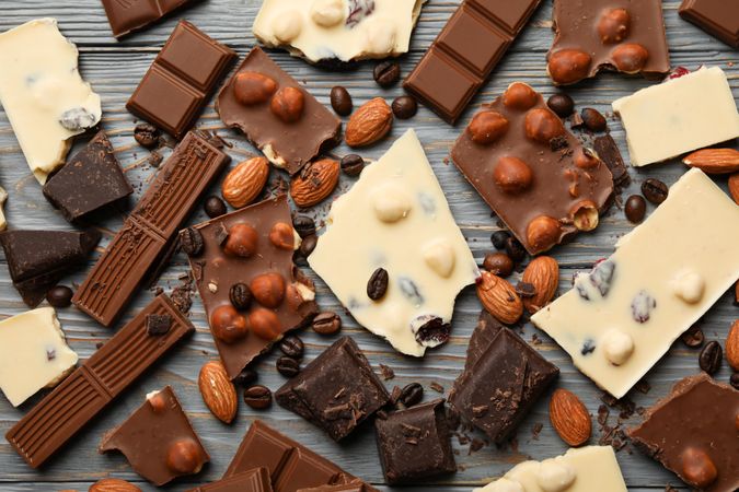 Different chocolate on gray wooden background, top view