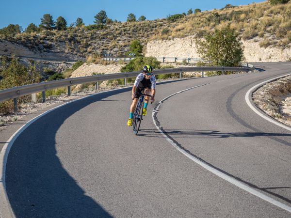 healthy man riding a bicycle on a mountain road in a sunny day