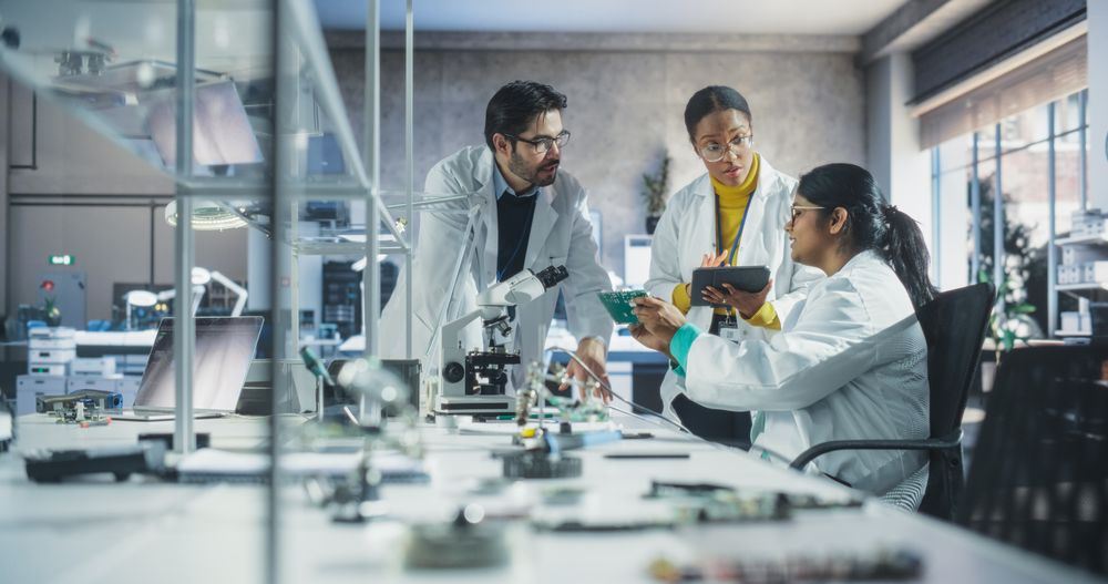 Young Indian Female Having a Conversation with Science Teachers in a Laboratory.