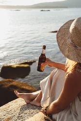Woman relaxing and drinking beer at beach