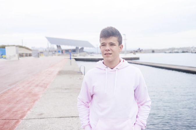 Young teenager walking on promenade while looking in the distance