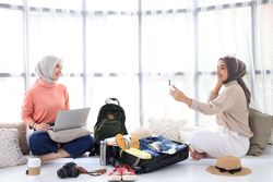 Two Young Asian Women Prepare for Summer Trip, Book Tickets Using Laptop and Take Selfies for Today's Outfits