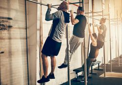 Group of people doing chin ups in gym class