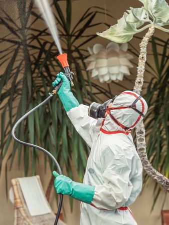 Fumigator in uniform spraying substance on garden