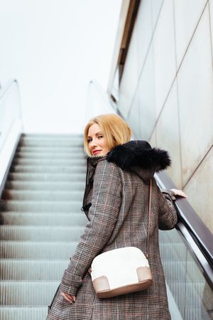Blonde woman climbing escalators