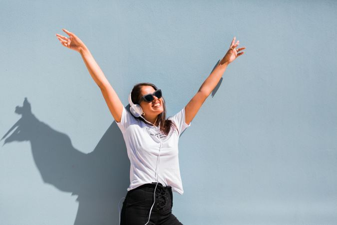 Cheerful casual woman in sunglasses standing on city street