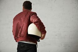 Rearshot of man in dark red leather jacket holding helmet