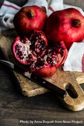 Fresh cut pomegranate on board with dish towel 49vRBb