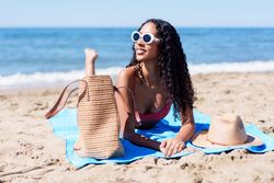 SunKissed Woman Enjoying Relaxation on the Sandy Beach Under the Bright Sunshine