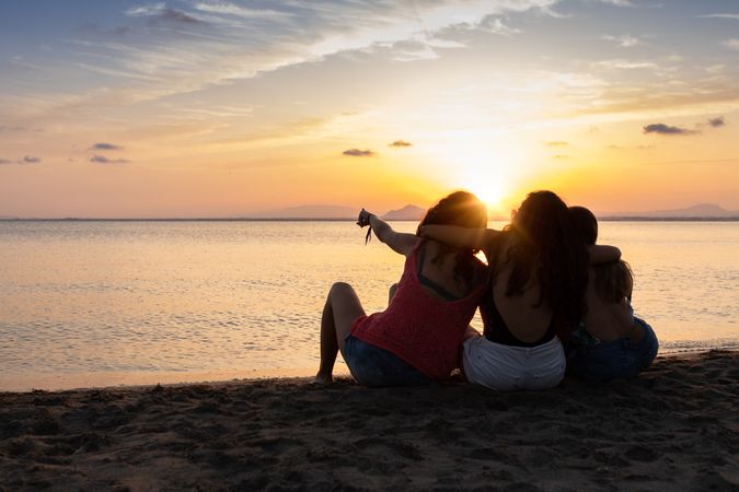 Peaceful fellows embracing on seashore