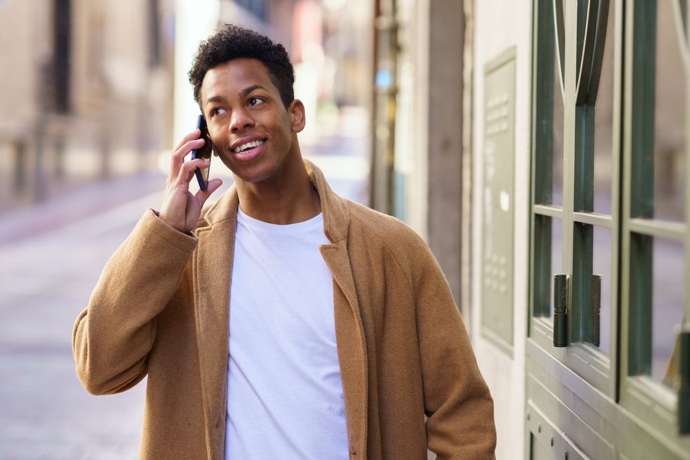 Cuban male chatting on his phone and walking