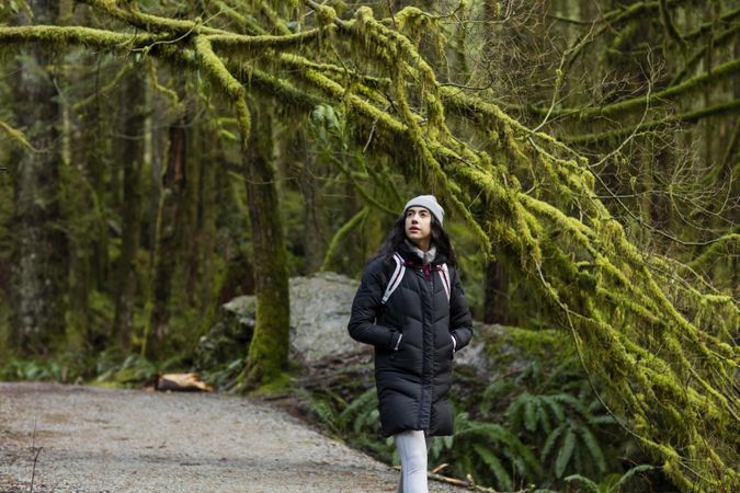 Young woman hiking amongst tall trees