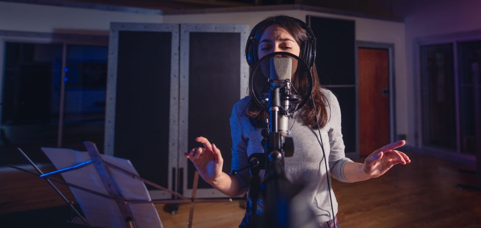 Young music artist singing a song in the recording studio