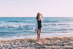 Woman in bathing suit standing by the ocean 5wa8Ab
