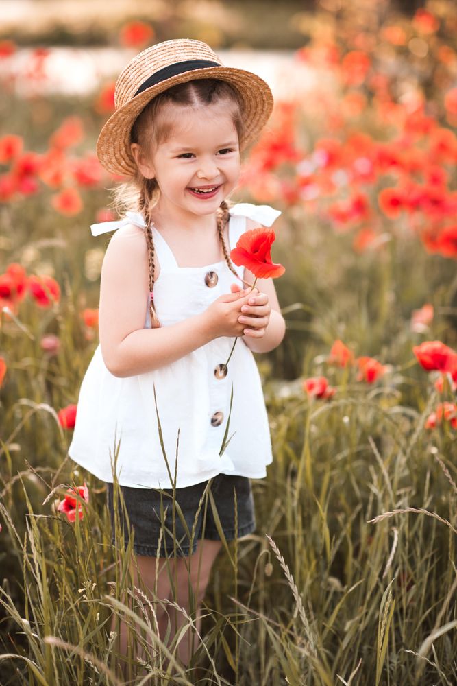 Happy girl standing in red meadow