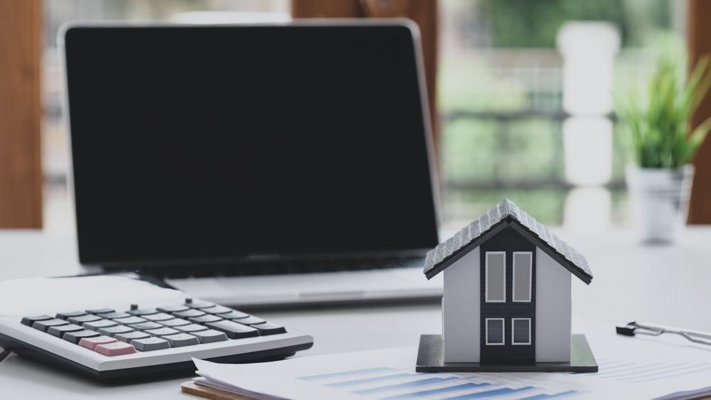 Model house puts a graph document with a calculator and a laptop